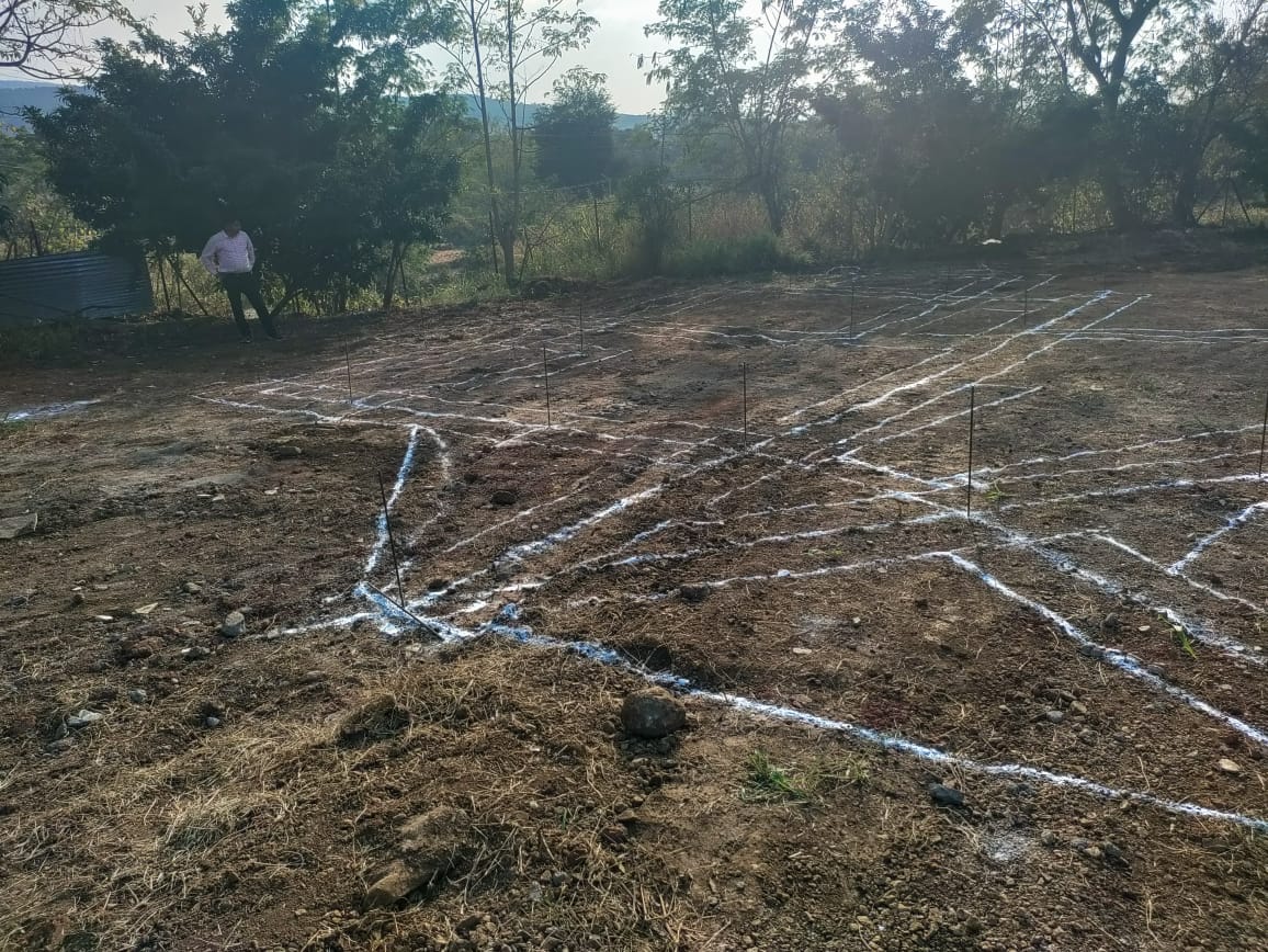 Building footprint marked with white lime lines and reference stakes